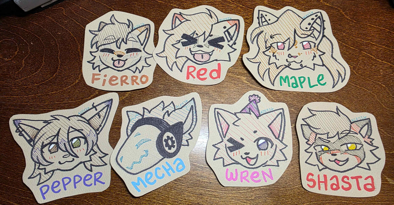 Photo of a bunch of badge art before it has been laminated!